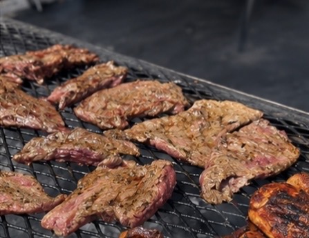 Hand-cut skirt steak searing on the charcoal grill